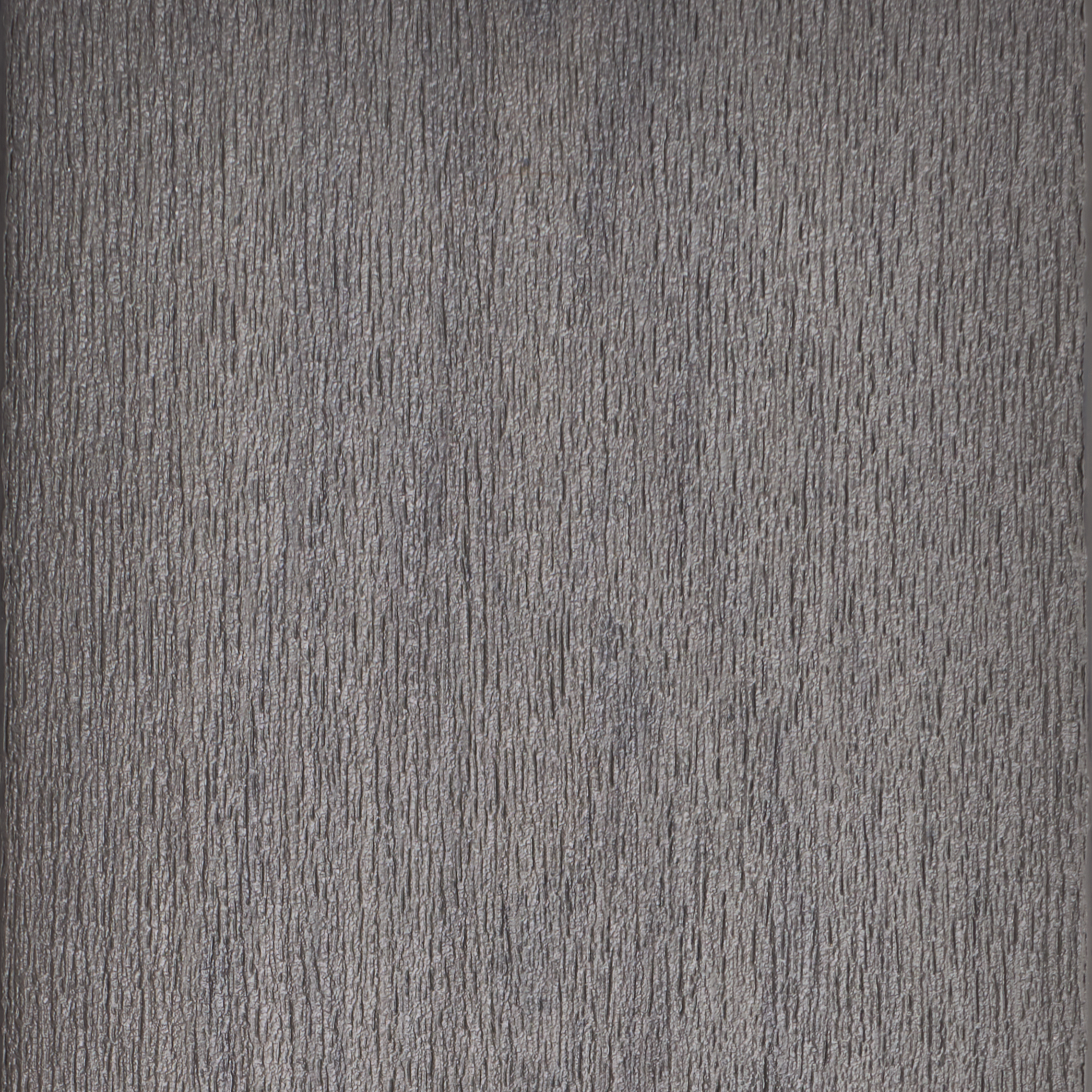 A close-up view of a textured gray surface featuring vertical linear patterns. The material appears rough and fibrous, suggesting a natural or synthetic composition. The neutral gray tone provides a versatile backdrop suitable for various design applications.
